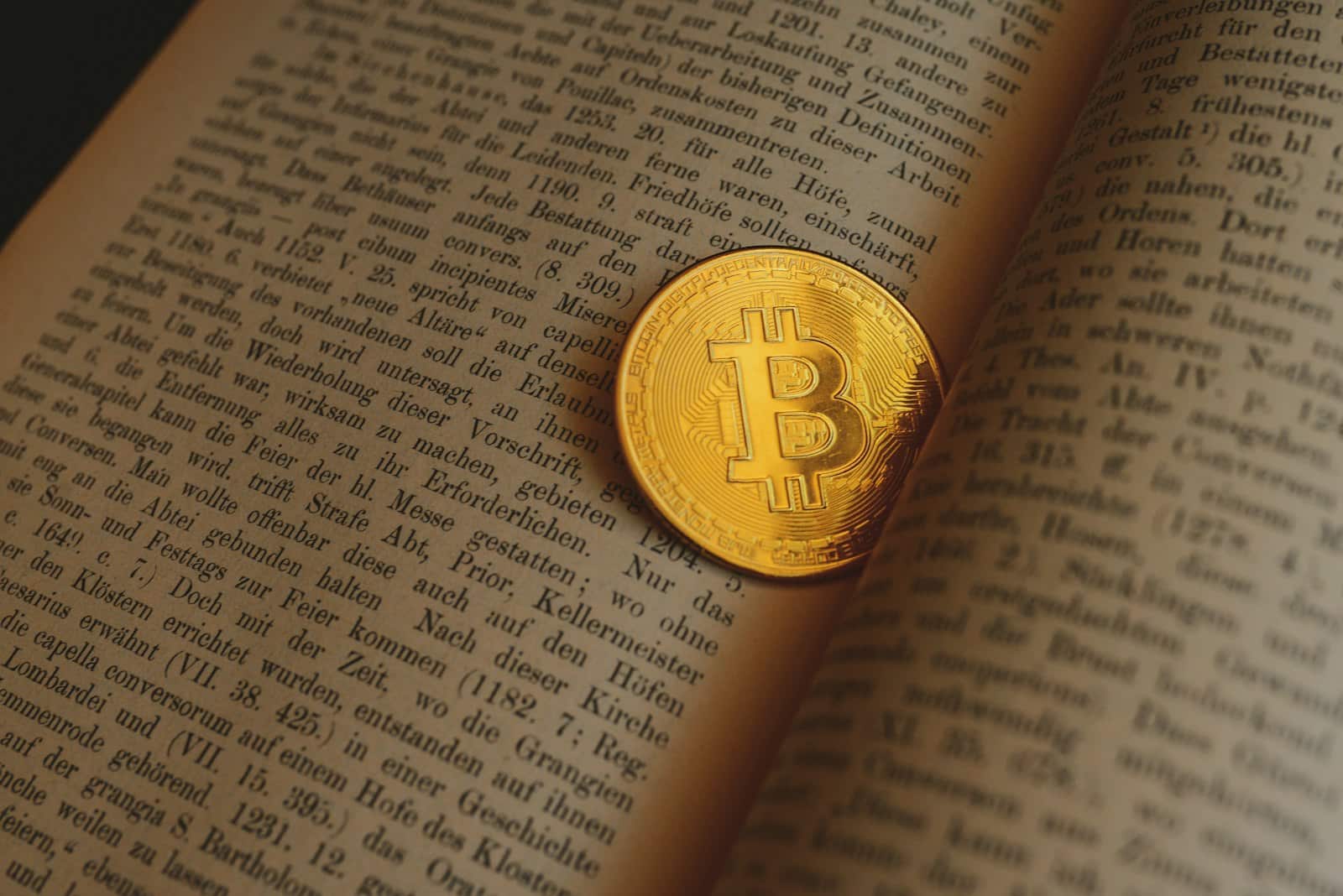 A bitcoin sitting on top of an open book