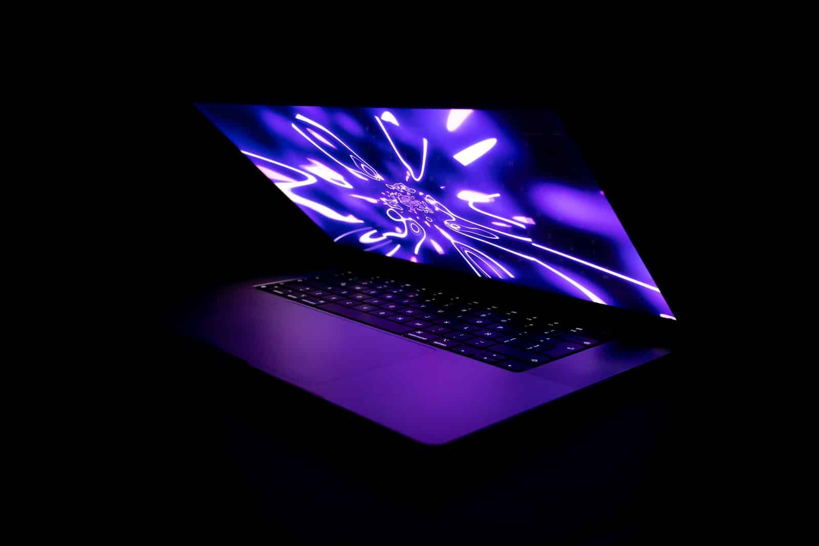 A laptop glowing in a dark room at night