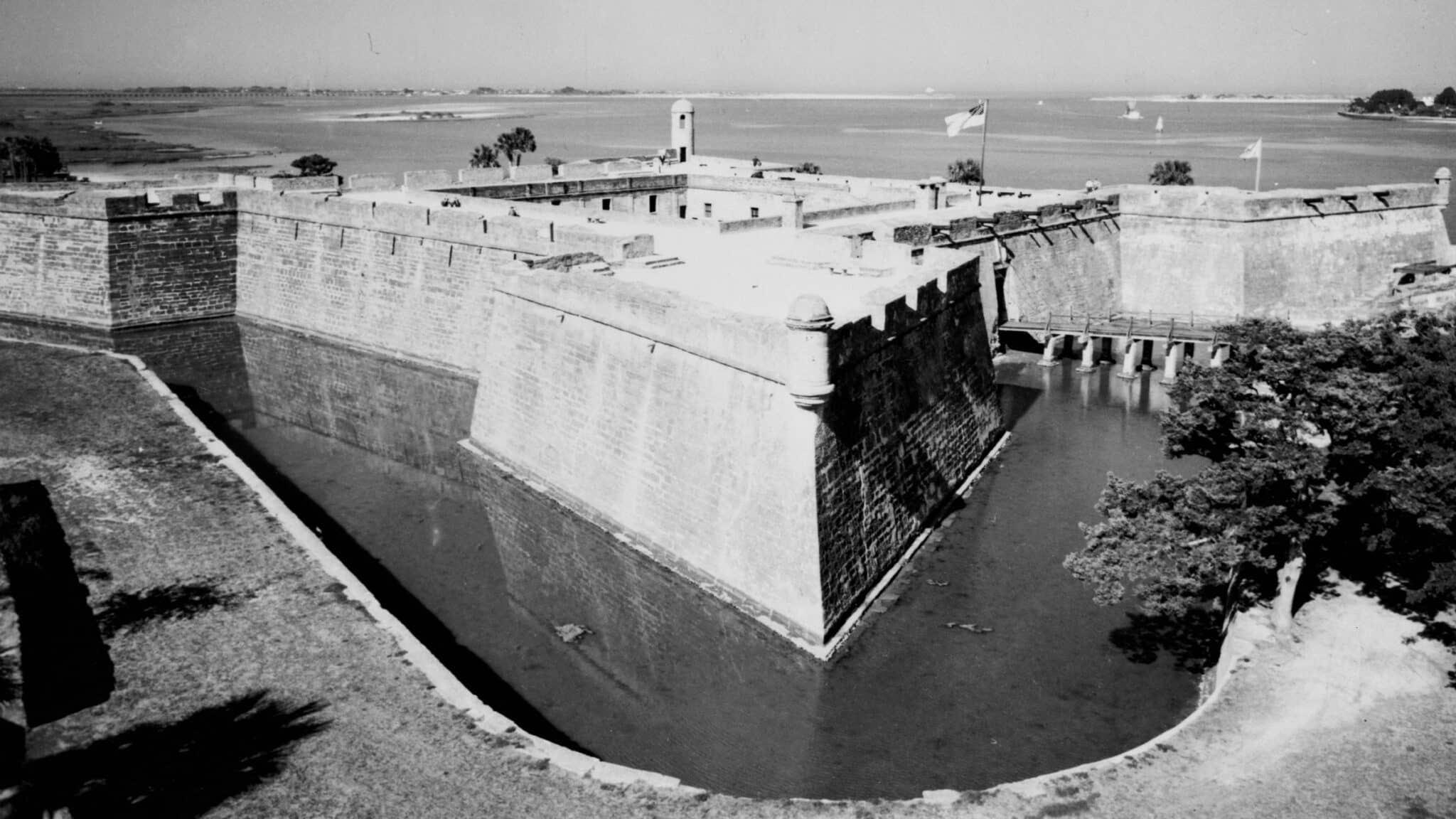 Aerial view of the Castillo de San Marcos, its stone bastion rising directly out of a water-filled moat