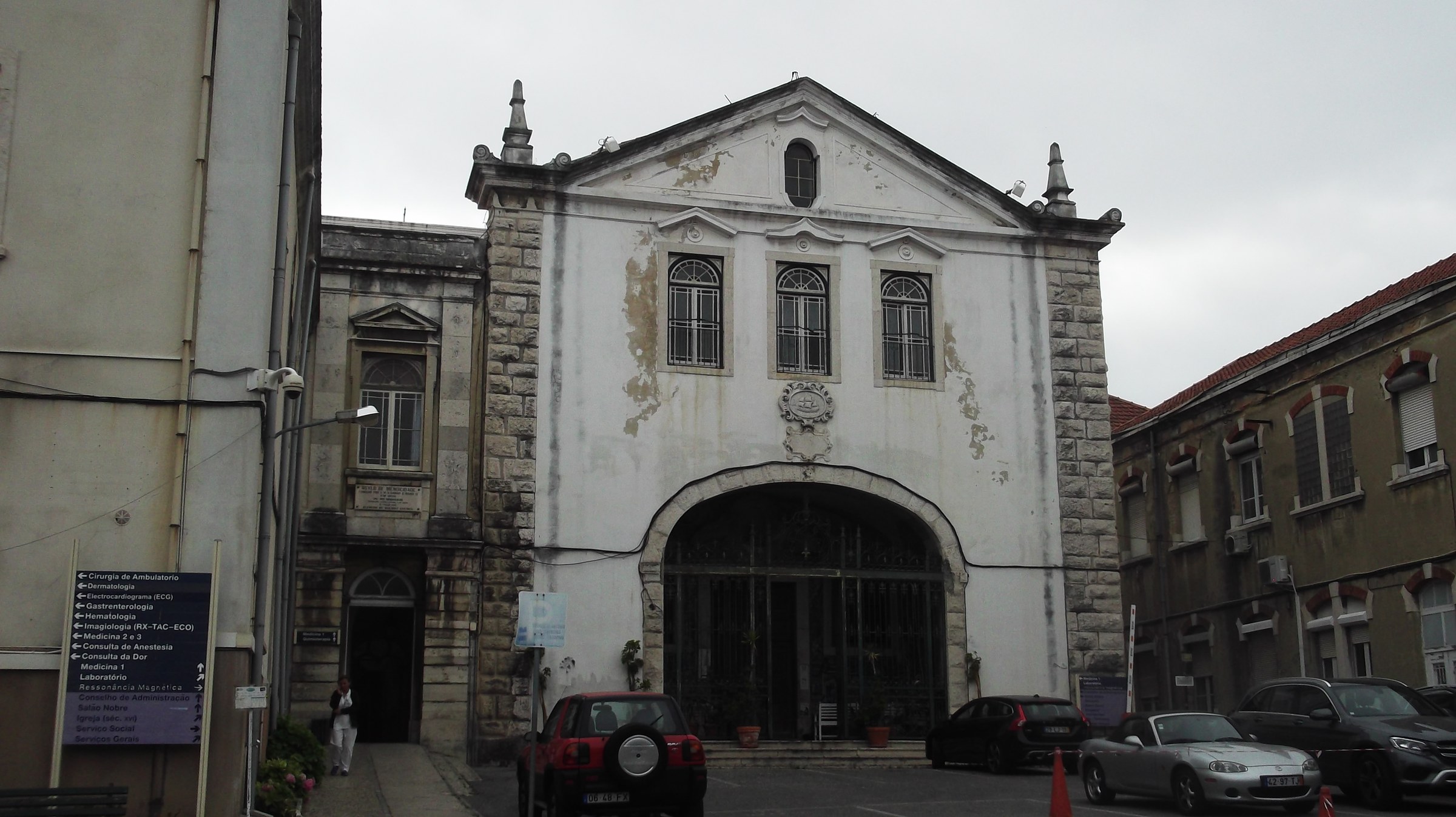 Entrance to Hospital de Santo Antonio dos Capuchos in Lisbon, with a Portuguese departmental signboard listing outpatient services